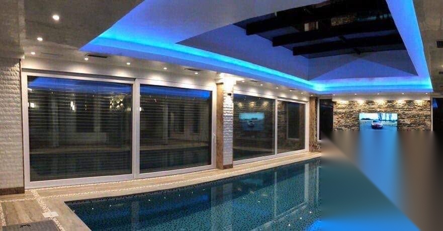Grandes baies coulissantes autour d'une piscine intérieure