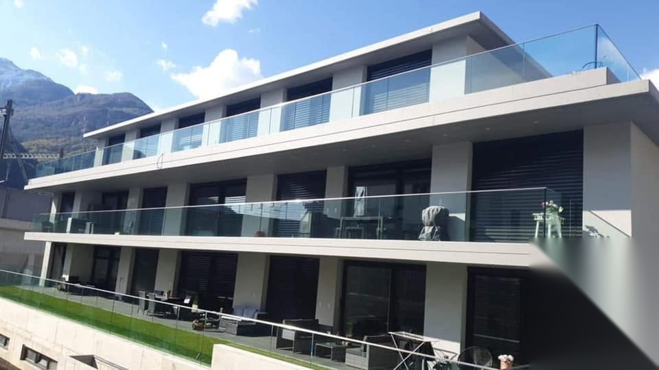 Façade moderne avec châssis noirs et garde-corps en verre